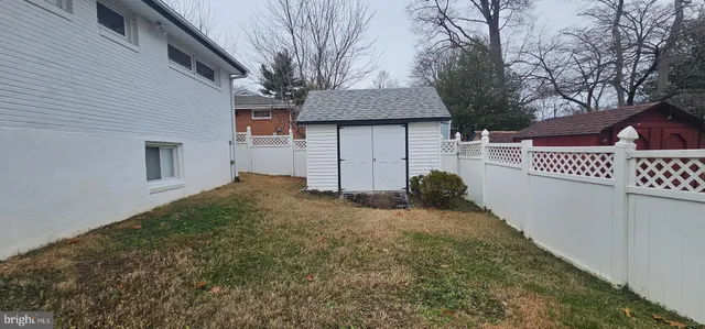 a view of a house with backyard and trees