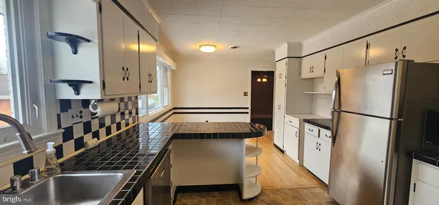 a kitchen with stainless steel appliances granite countertop a refrigerator and a sink