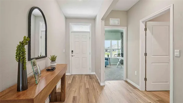 a view of a hallway view with wooden floor and a living room