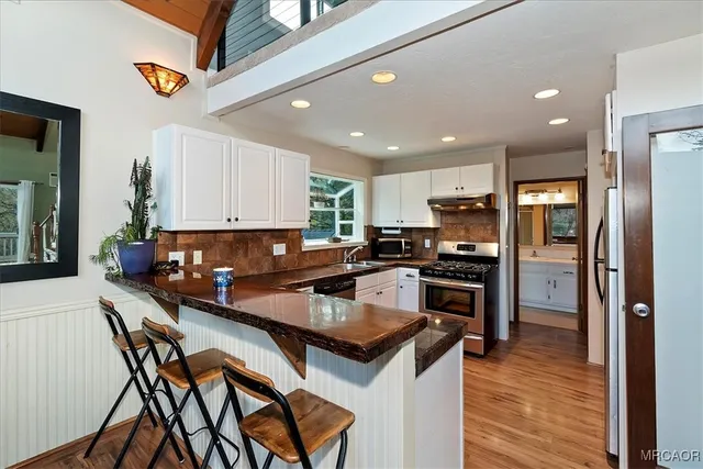 a kitchen with a sink a counter top space stainless steel appliances and cabinets