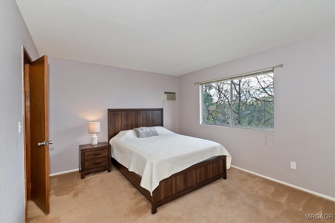 26822 Huron Road Lake Arrowhead, CA 92391 - Photo 25 of 38 a bed sitting in a bedroom next to a window