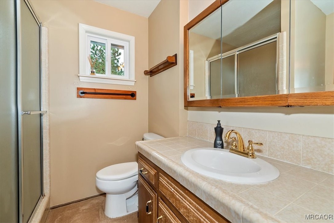 26822 Huron Road Lake Arrowhead, CA 92391 - Photo 27 of 38 a bathroom with a granite countertop sink toilet and a mirror