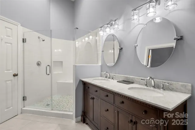 a bathroom with a double vanity sink mirror and shower