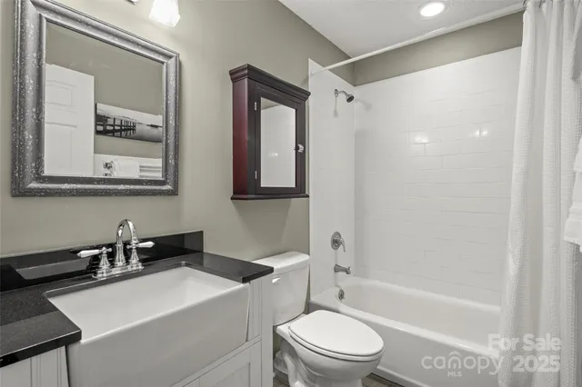 a bathroom with a sink a toilet a mirror and shower