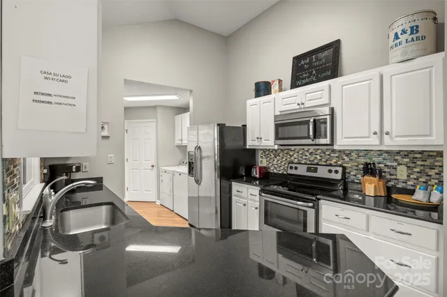 a kitchen with stainless steel appliances a sink a stove and cabinets