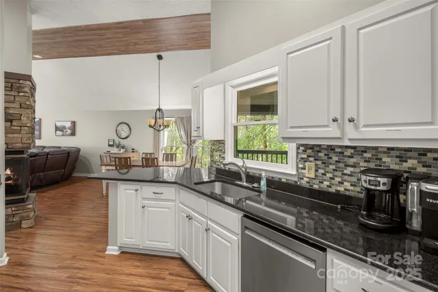 a kitchen with stainless steel appliances granite countertop a stove a sink and white cabinets