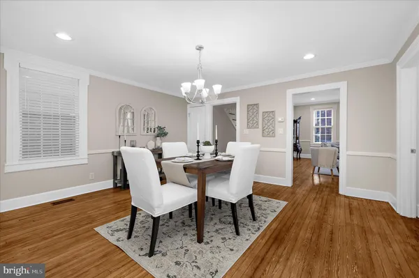 a kitchen with granite countertop a sink chairs and white cabinets