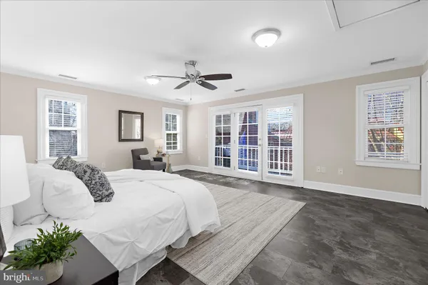 an empty room with wooden floor and a ceiling fan