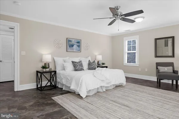 a view of an empty room with wooden floor and a ceiling fan