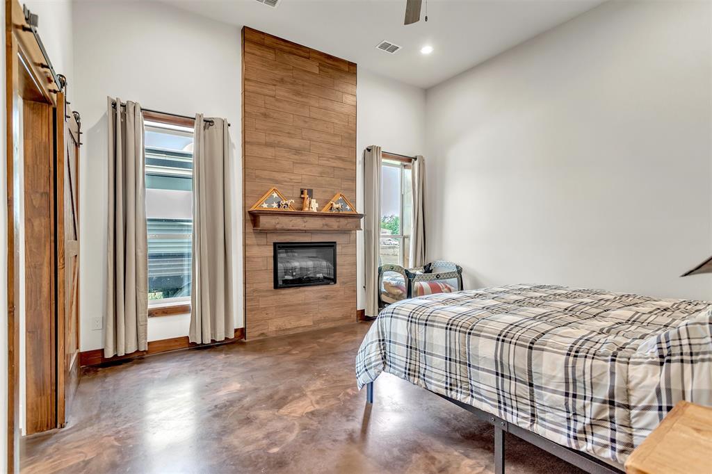 13831 Friendship Road Pilot Point, TX 76258 - Photo 8 of 31 a bedroom with a bed and a fireplace