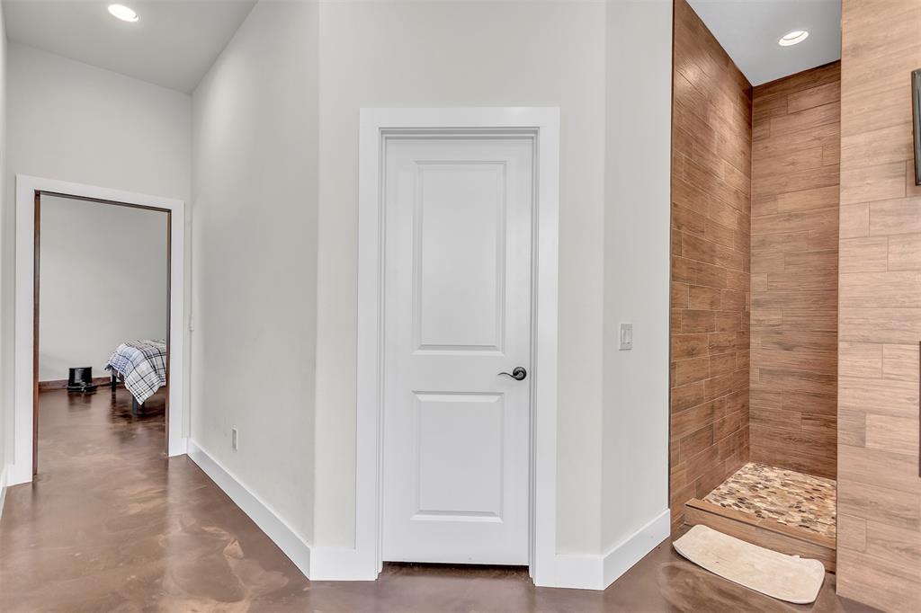 13831 Friendship Road Pilot Point, TX 76258 - Photo 10 of 31 Entering this luxury primary bathroom first is the very good size closet. Next is the double shower with a fireplace and TV on outer wall, facing jetted tub. Wait till you see the double vanities with double sinks and finished concrete flooring, high ceiling and recessed lighting