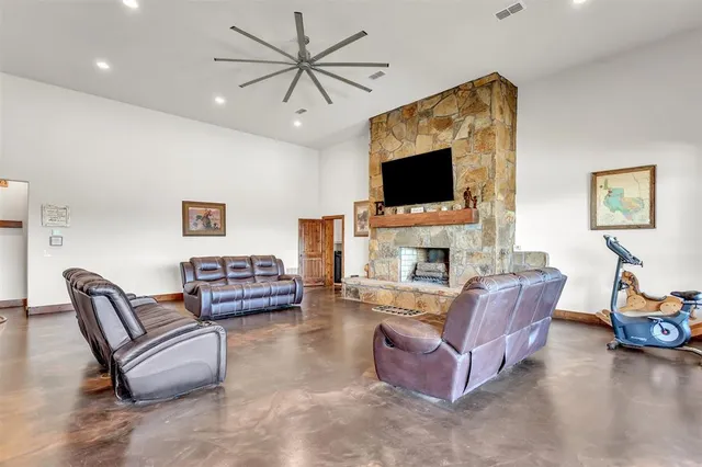 a kitchen with stainless steel appliances granite countertop a refrigerator a sink dishwasher a stove a dining table and chairs with wooden floor