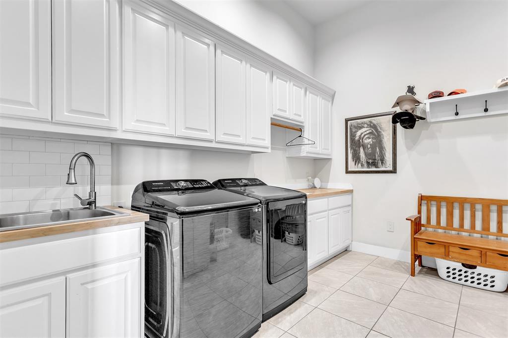 13831 Friendship Road Pilot Point, TX 76258 - Photo 20 of 31 Laundry room featuring washer and dryer, cabinet space, and light tile patterned floors