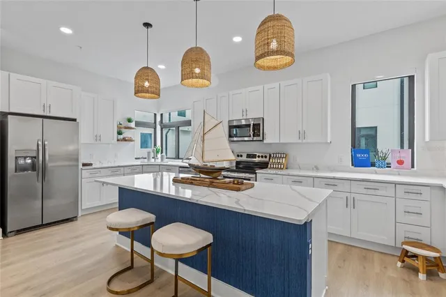 a kitchen with a center island appliances and cabinets