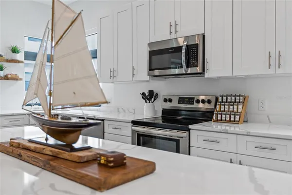 a kitchen with stainless steel appliances kitchen island granite countertop a sink a stove and a microwave