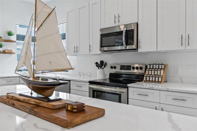 a kitchen with stainless steel appliances kitchen island granite countertop a sink a stove and a microwave