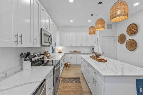 a kitchen that has a lot of cabinets and a wooden floor