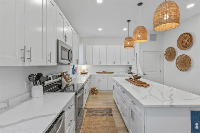 a kitchen that has a lot of cabinets and a wooden floor