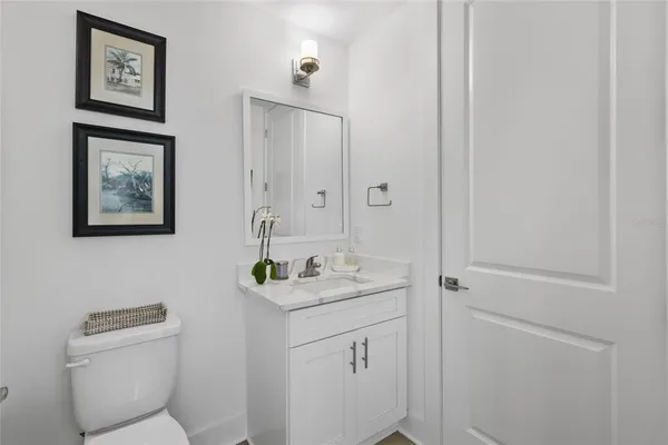 a bathroom with a toilet sink vanity and mirror