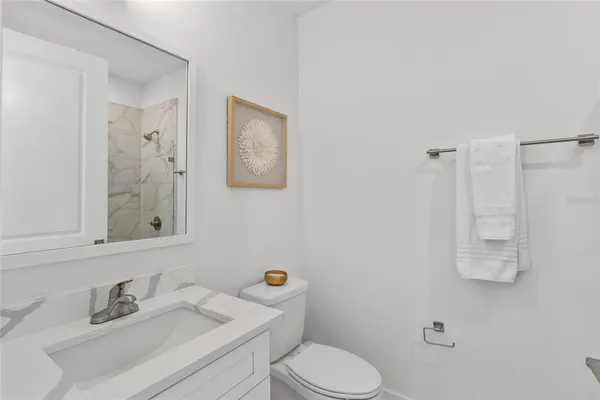 a bathroom with a sink mirror vanity and toilet