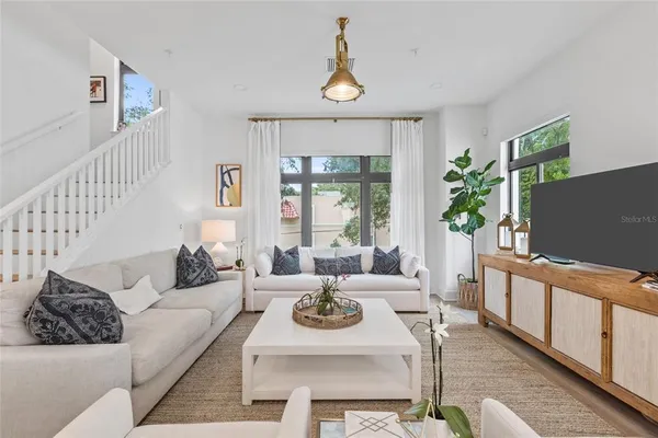 a living room with furniture a window and a flat screen tv