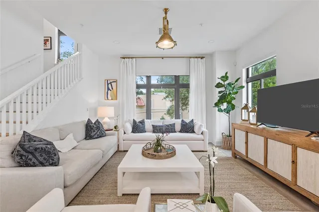 a living room with furniture a window and a flat screen tv