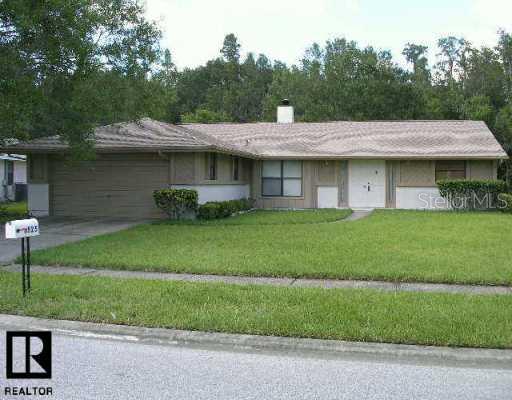 a front view of a house with a garden and plants