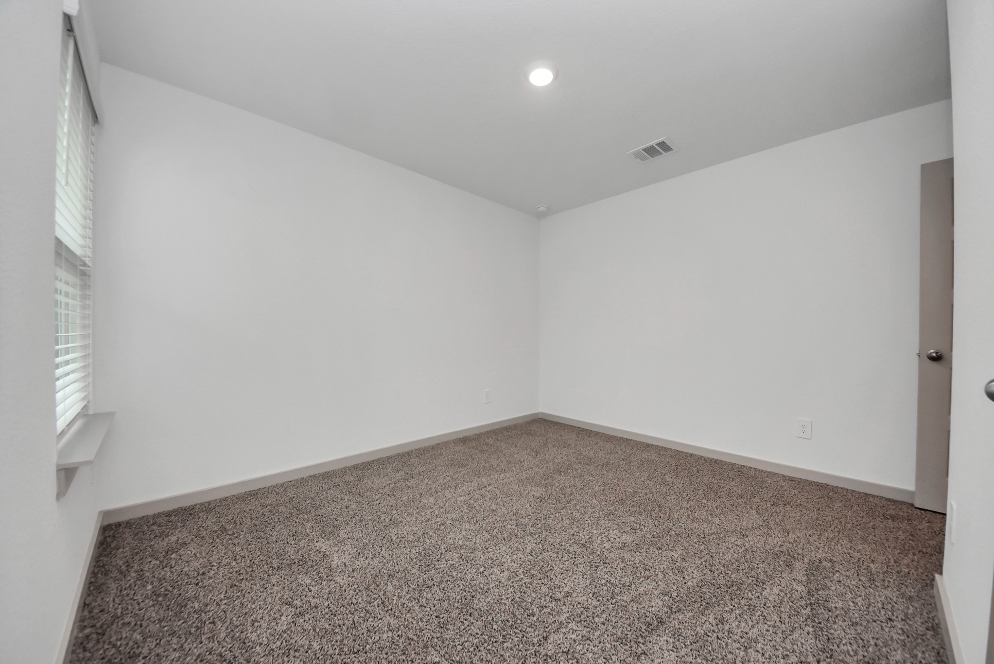 7911 Wrangler Shack Lane Rosharon, TX 77583 - Photo 15 of 40 Bright and inviting room with plush carpet and ample natural light from large windows, perfect for a cozy retreat.