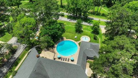 an aerial view of a house with outdoor space and tennis court