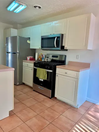 a kitchen with stainless steel appliances granite countertop a stove a microwave and a refrigerator