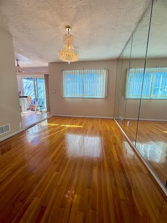 a view of empty room with wooden floor