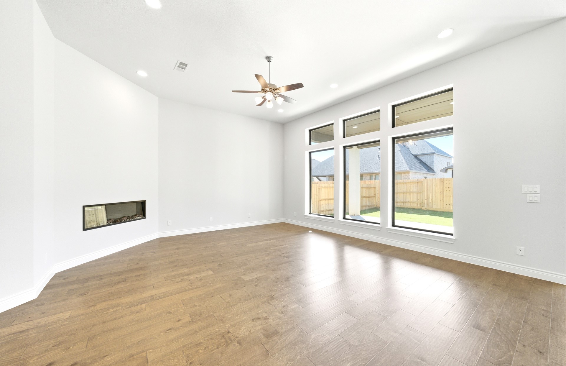 38642 Night Brood Court Magnolia, TX 77354 - Photo 14 of 32 an empty room with wooden floor chandelier fan and windows