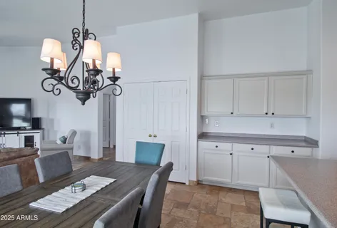 a view of a dining room with furniture a chandelier and wooden floor