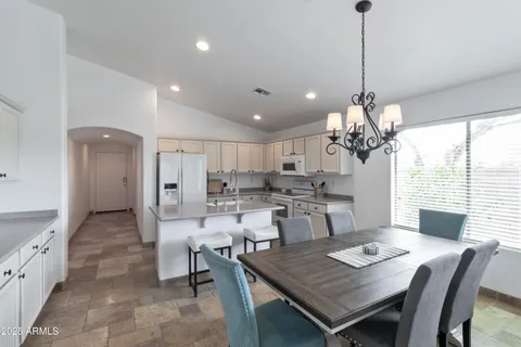 a view of a dining room and livingroom with furniture wooden floor a chandelier