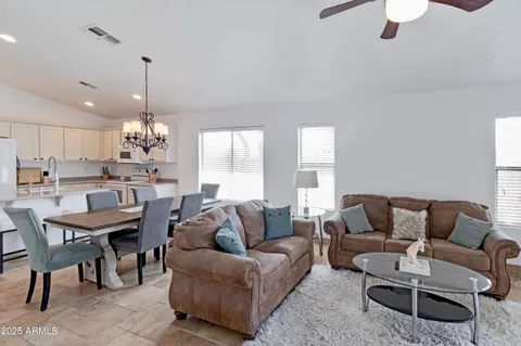 a living room with furniture kitchen and a chandelier