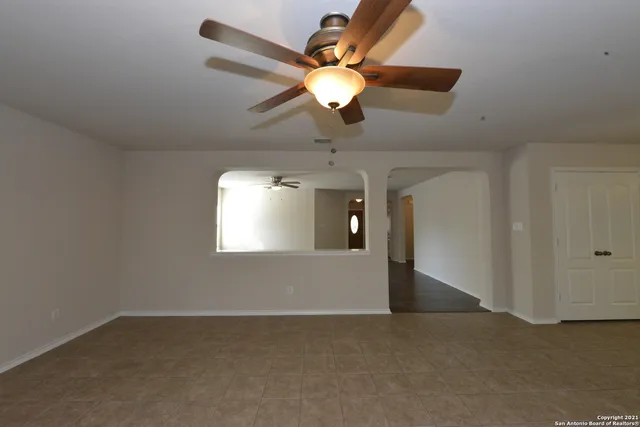 en empty room with windows and fan