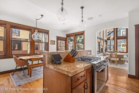 a living room with granite countertop furniture a dining table and chairs with wooden floor