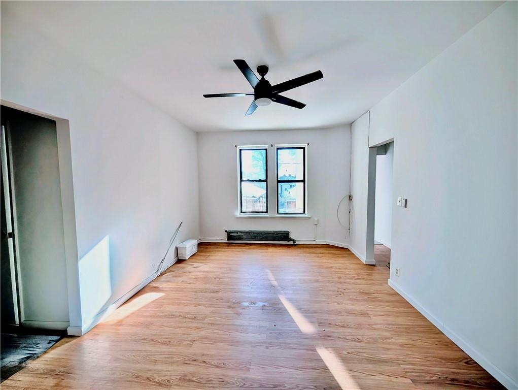 7501 Ridge Boulevard, Unit 2E Brooklyn, NY 11209 - Photo 7 of 13 an empty room with wooden floor ceiling fan and windows