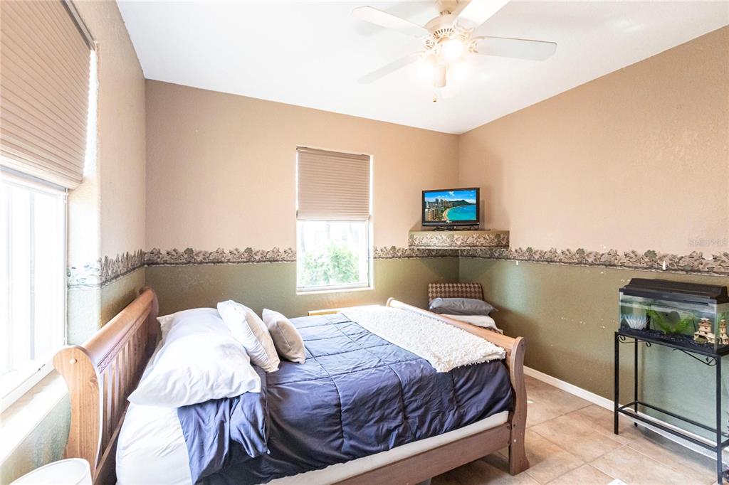 27199 Punta Cabello Court Punta Gorda, FL 33983 - Photo 35 of 45 a bedroom with a bed and a chandelier