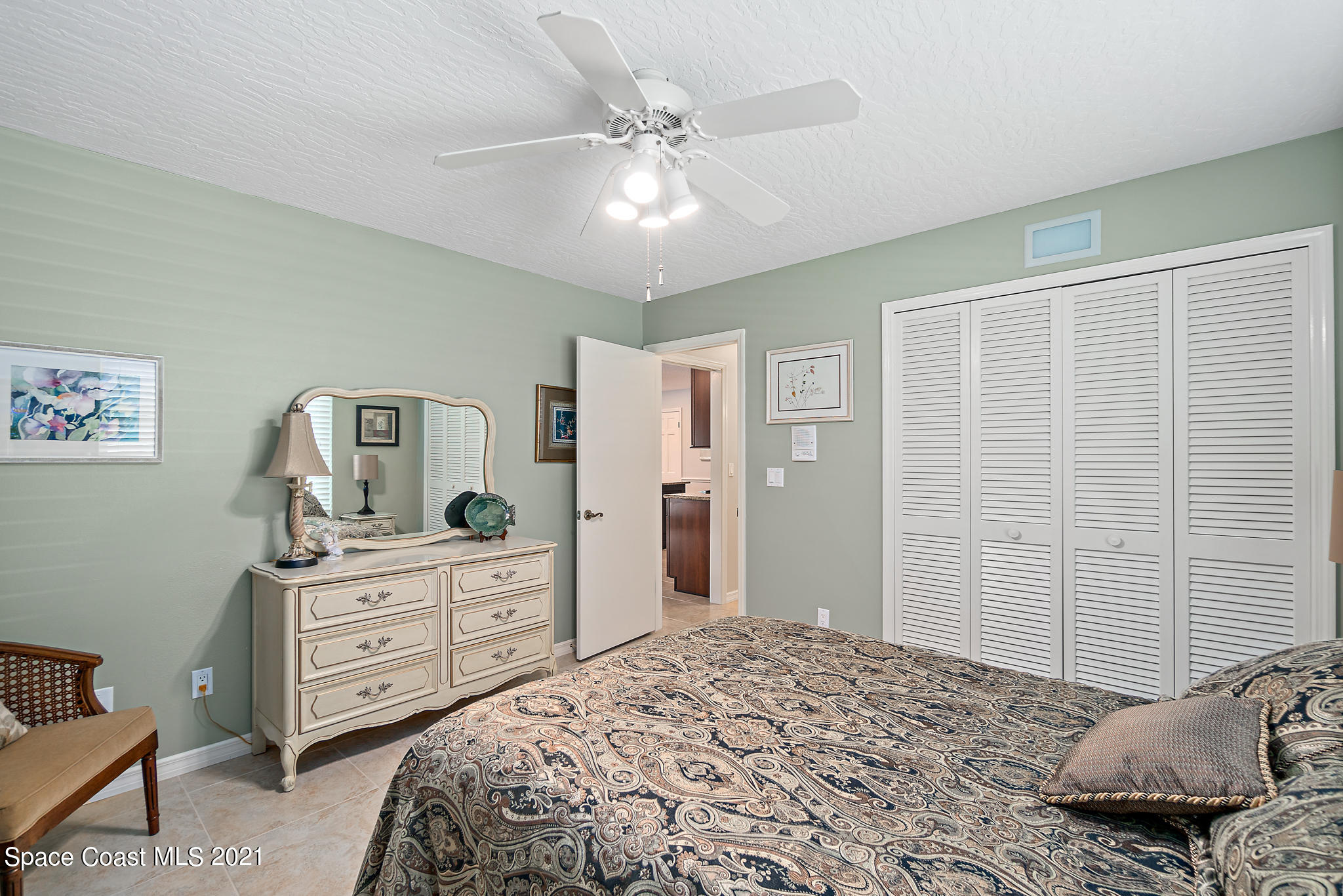 539 Lanternback Island Drive Satellite Beach, FL 32937 - Photo 31 of 54 a bedroom with a bed and a chandelier