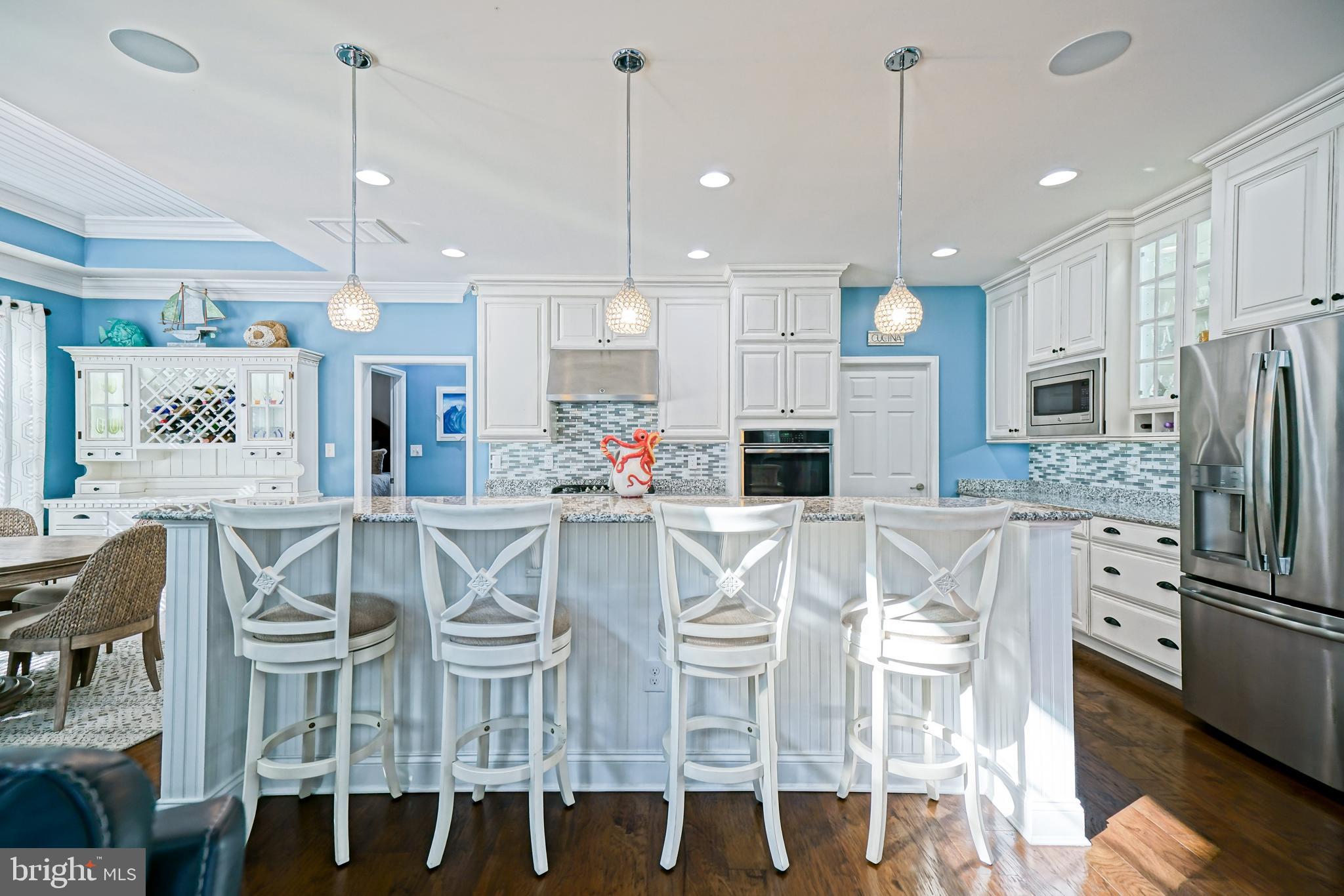 35236 Acadia Lane Lewes, DE 19958 - Photo 18 of 88 a kitchen with stainless steel appliances kitchen island granite countertop a dining table chairs and white cabinets