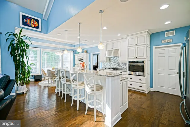 a living room with furniture a large window a fireplace and a chandelier