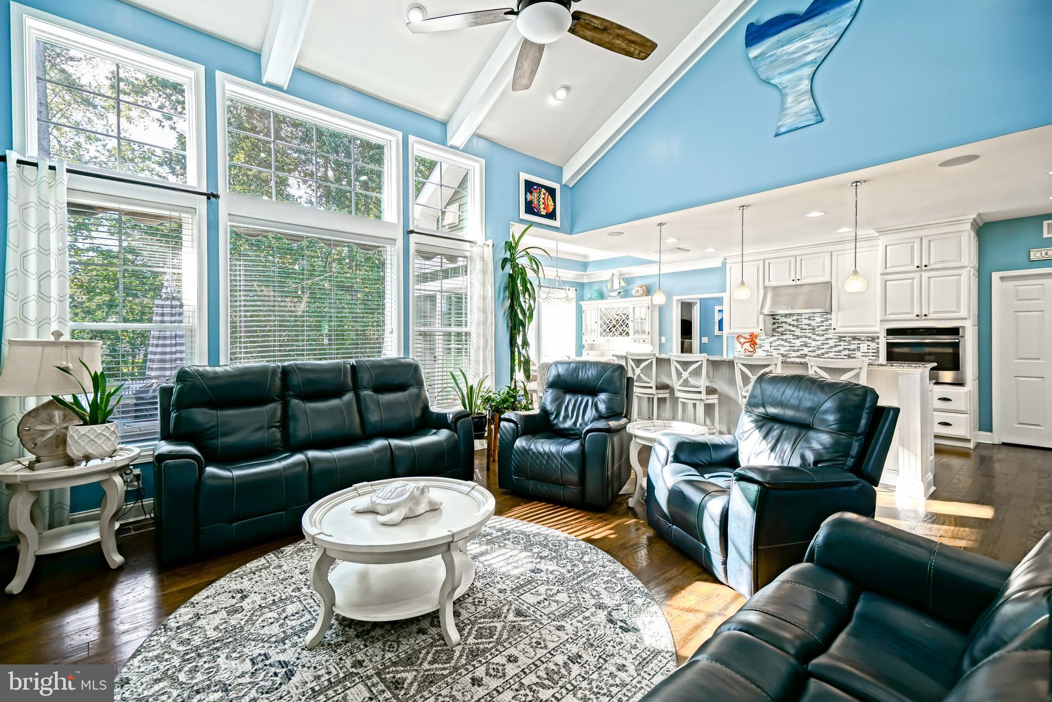 35236 Acadia Lane Lewes, DE 19958 - Photo 32 of 88 a living room with furniture a large window a fireplace and a chandelier