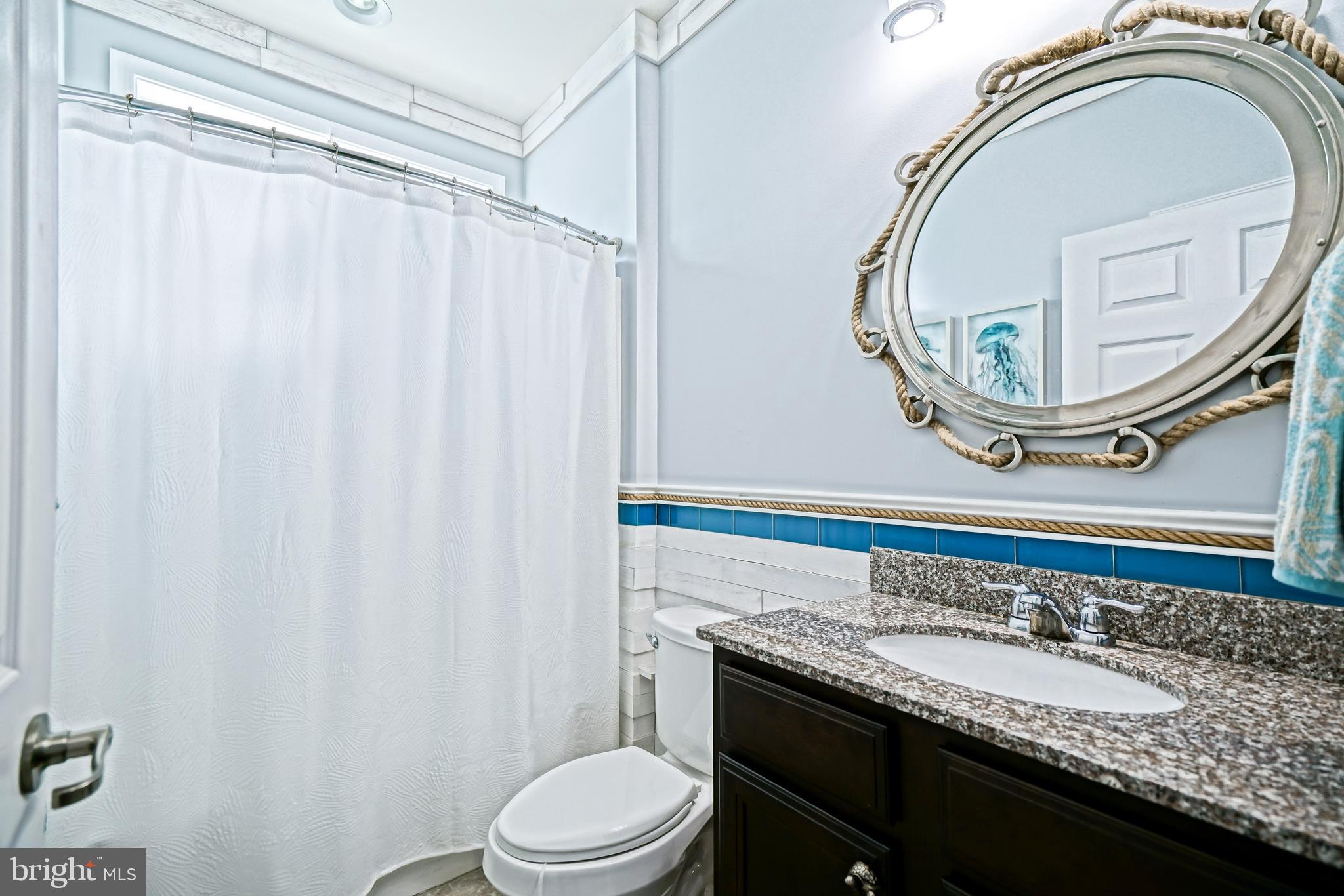 35236 Acadia Lane Lewes, DE 19958 - Photo 51 of 88 a bathroom with a granite countertop bathtub a sink and a mirror