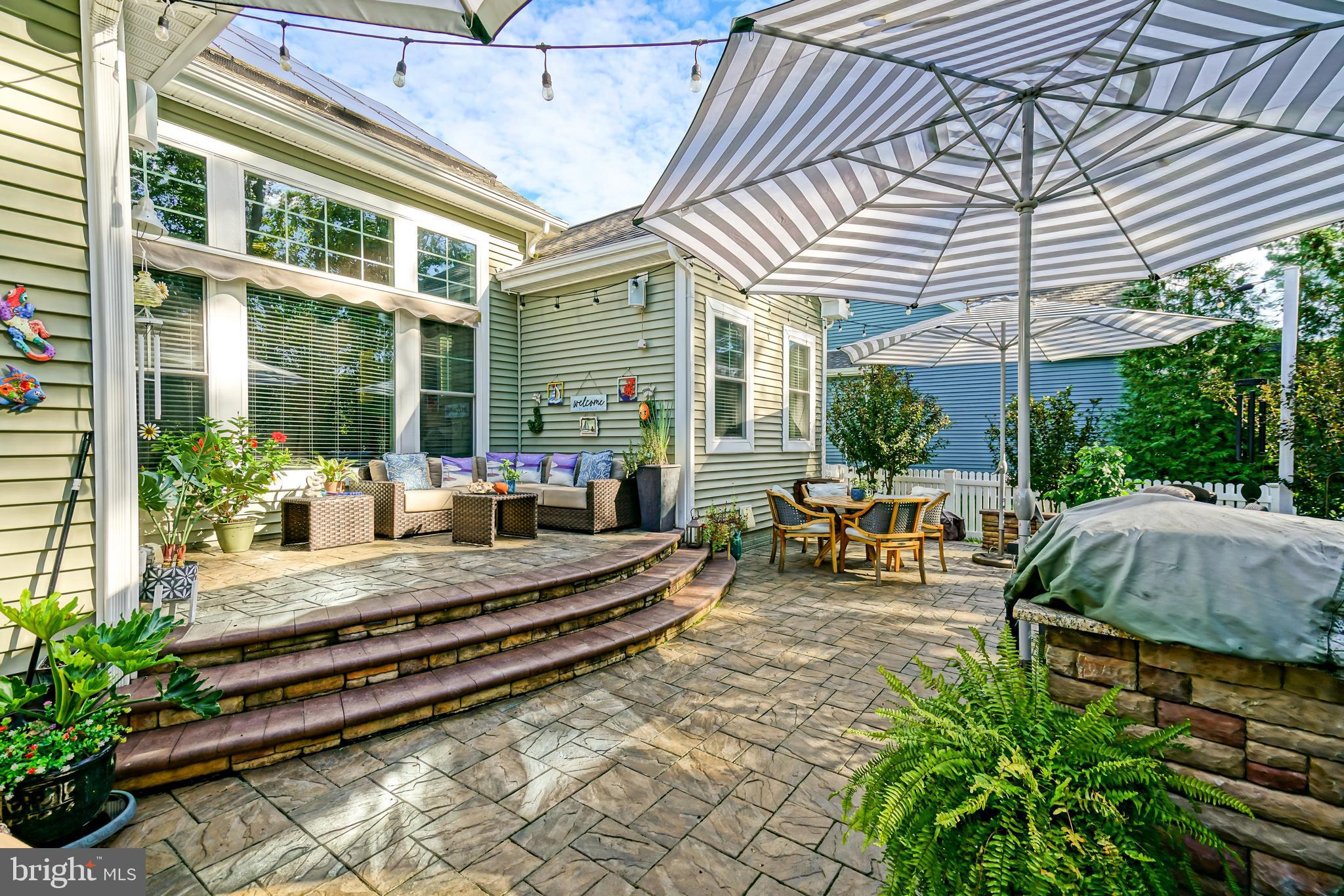 35236 Acadia Lane Lewes, DE 19958 - Photo 63 of 88 a view of a patio with table and chairs potted plants and floor to ceiling window and potted plants