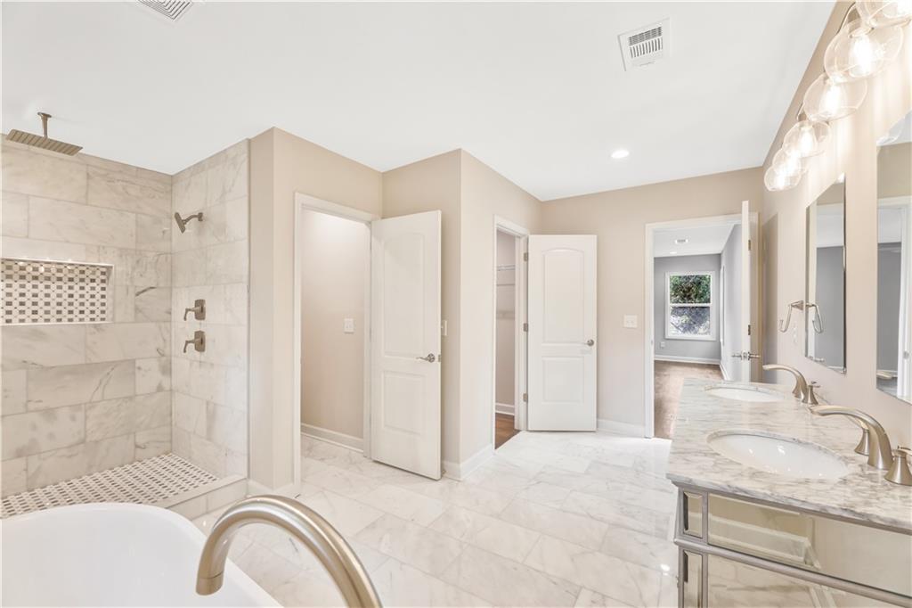 1776 Temple Avenue Atlanta, GA 30337 - Photo 15 of 18 a spacious bathroom with a granite countertop tub shower and mirror