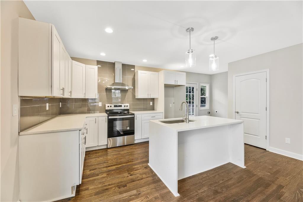 1776 Temple Avenue Atlanta, GA 30337 - Photo 5 of 18 a kitchen with a sink a stove a refrigerator and white cabinets