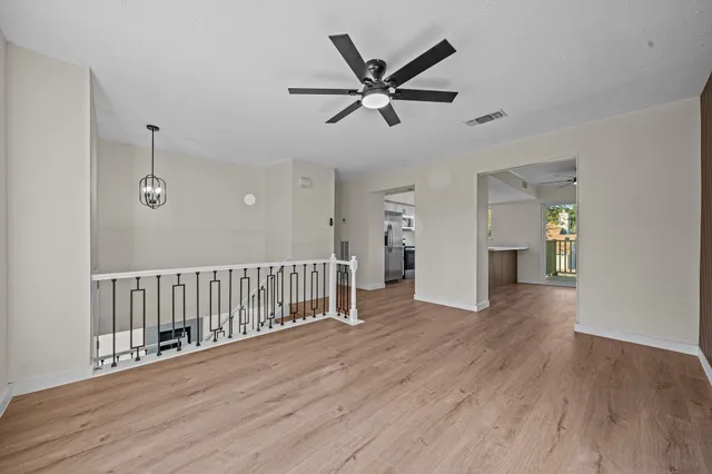 a kitchen with stainless steel appliances a stove a microwave a sink a refrigerator white cabinets and wooden floor