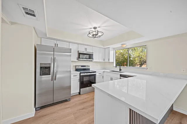 a view of a livingroom with a ceiling fan and wooden floor