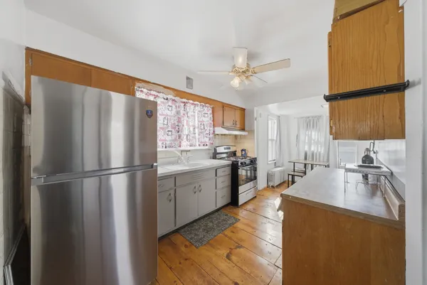 a kitchen with sink a refrigerator and white cabinets